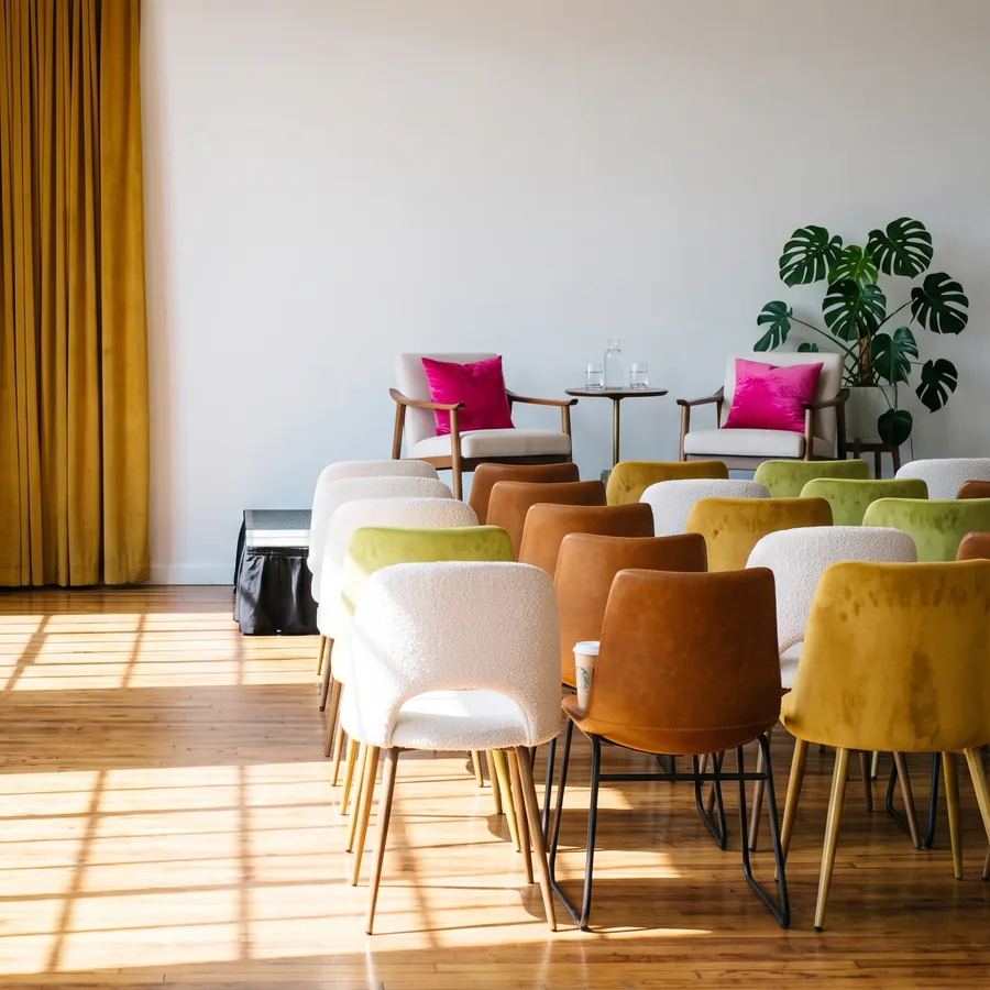 A sunlit room set with rows of chairs, ready for a session